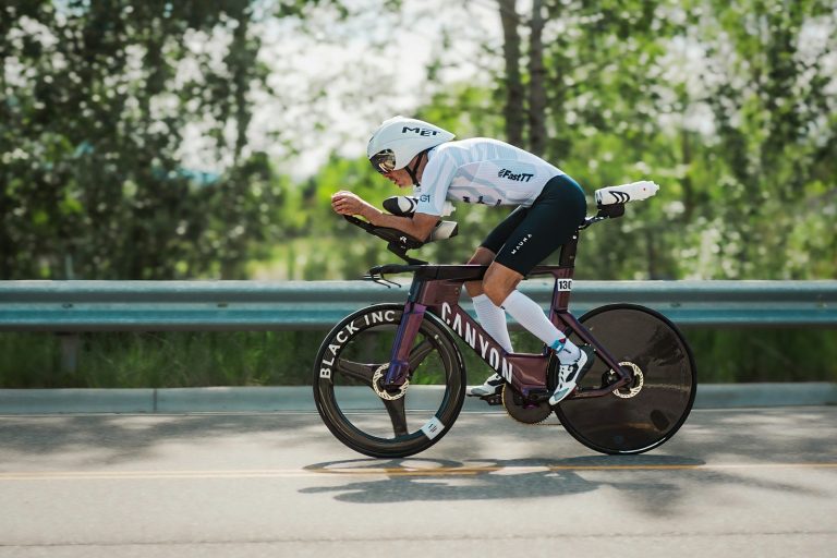 Triathlon competitor riding aerodynamic bike on road